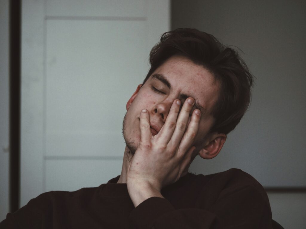 Exhausted man holding his head in his hand
